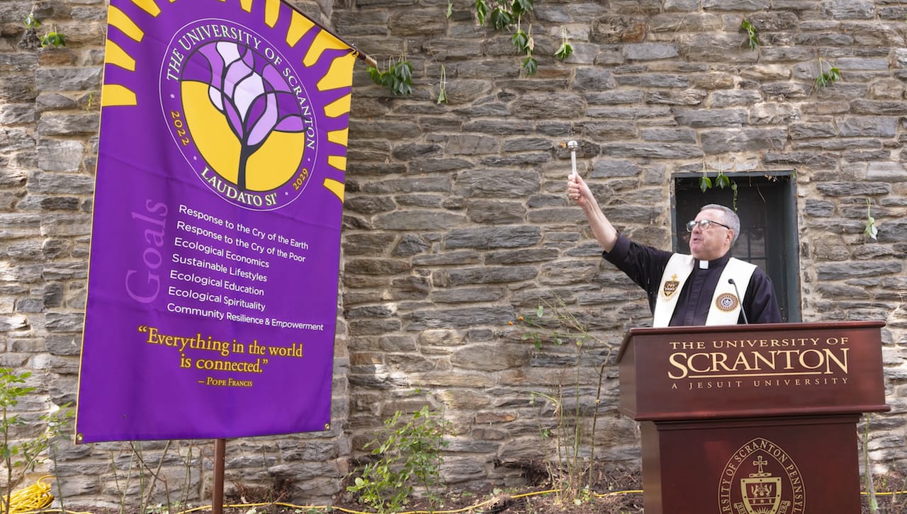 For the fifth year, The Princeton Review has recognized The University of Scranton for its commitment to sustainability initiatives in its recently published 2024 “Guide to Green Colleges.” Earlier this year, Scranton has begun a seven-year journey to be recognized by the Vatican as a Laudato Si’ University, answering the Pope’s call to “care for our common home.” Pictured: University of Scranton President Rev. Joseph Marina, S.J., blesses the University’s Laudato Si’ banner at the plan announcement event in September.