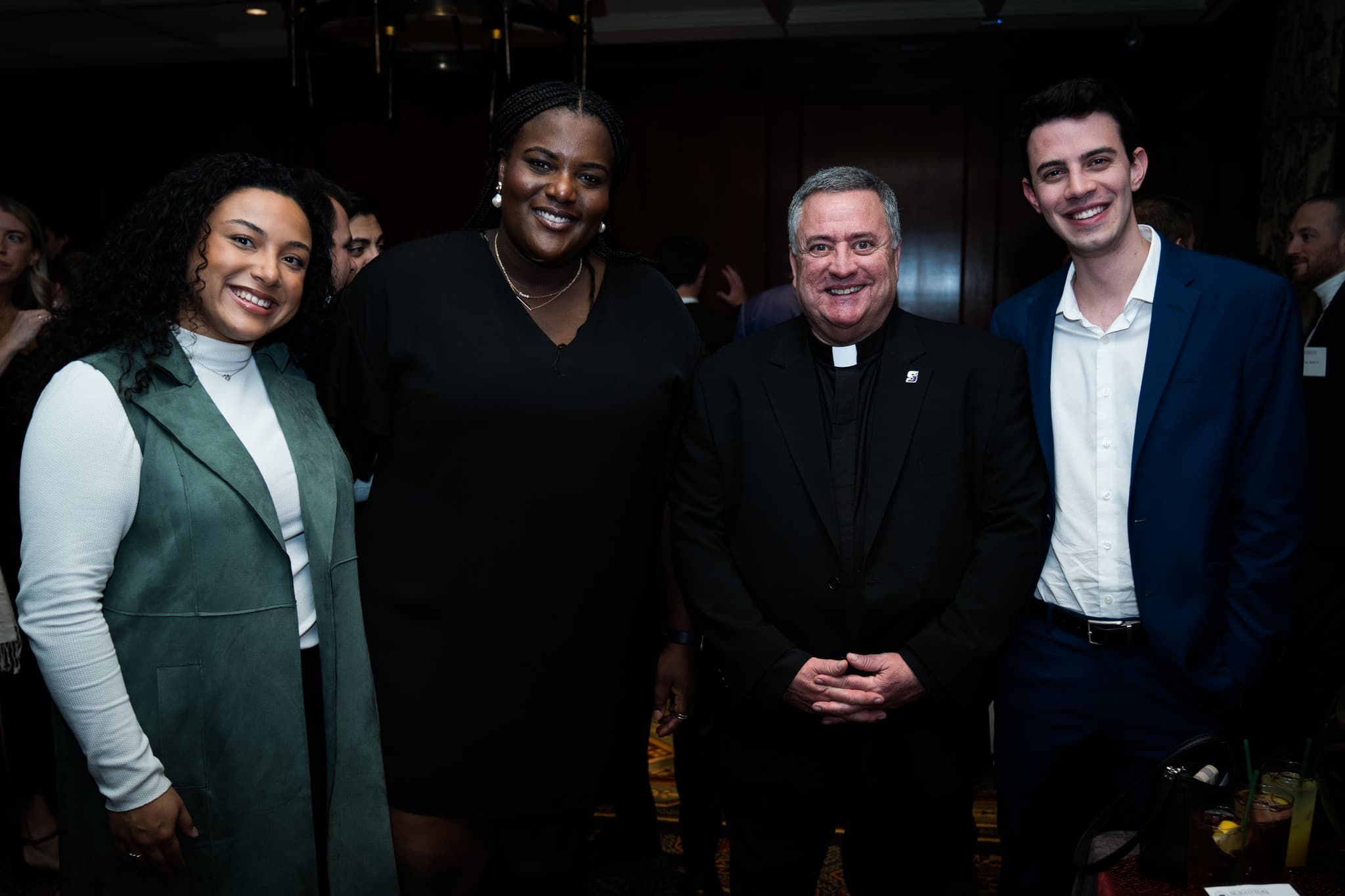 From left, Taylor Roman '21, Breanna Cole '21, Rev. Joseph G. Marina, S.J., University president, and Jeffrey Colucci '21 celebrate the Christmas season together at the New York Athletic Club in 2022.