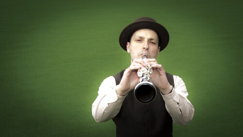 Man performing clarinet. image features a green background